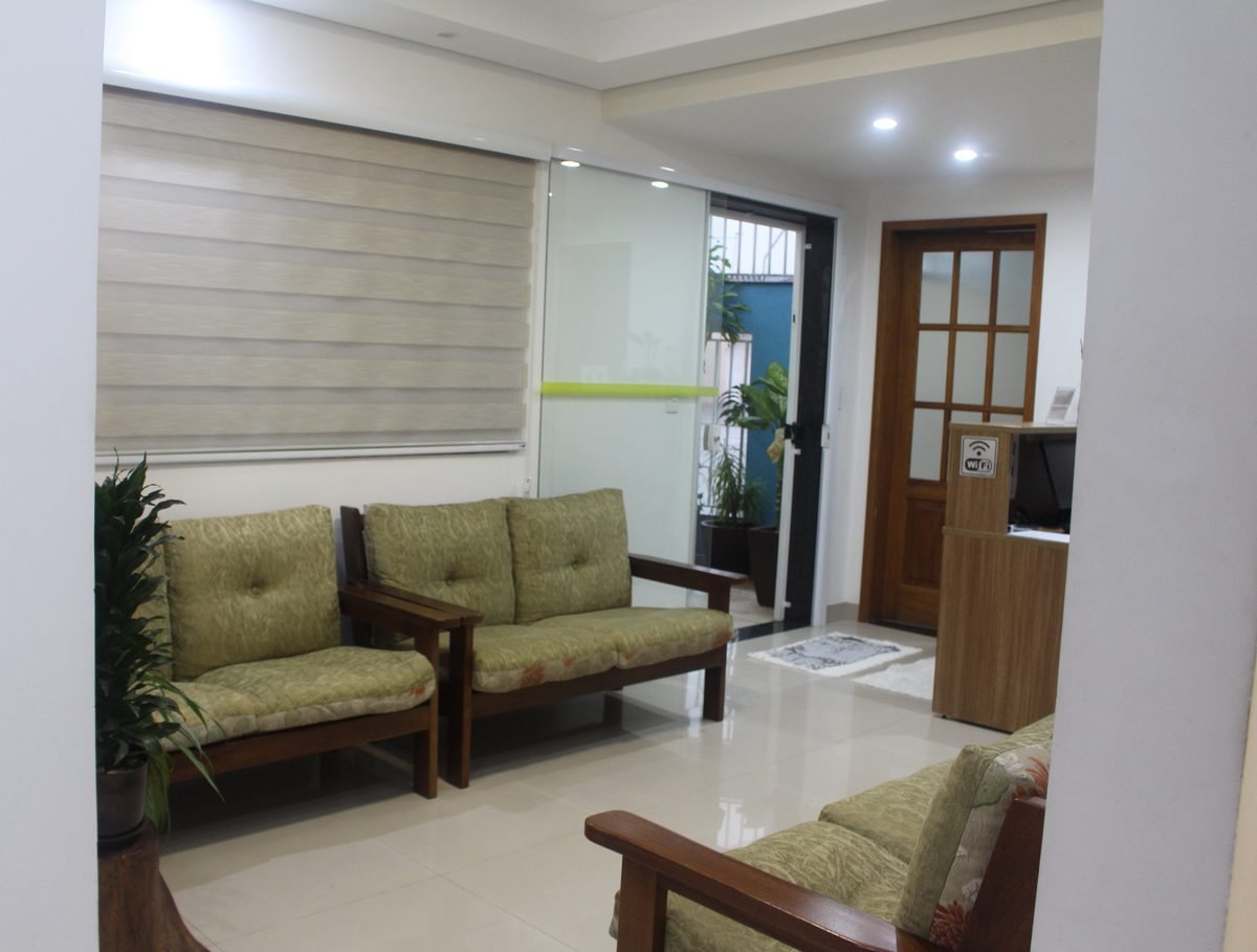 Sala de espera da Denflor, com poltronas, plantas e a recepção ao fundo